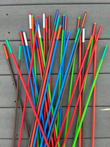 Colorful stakes in red, blue, green, and brown on a gray surface